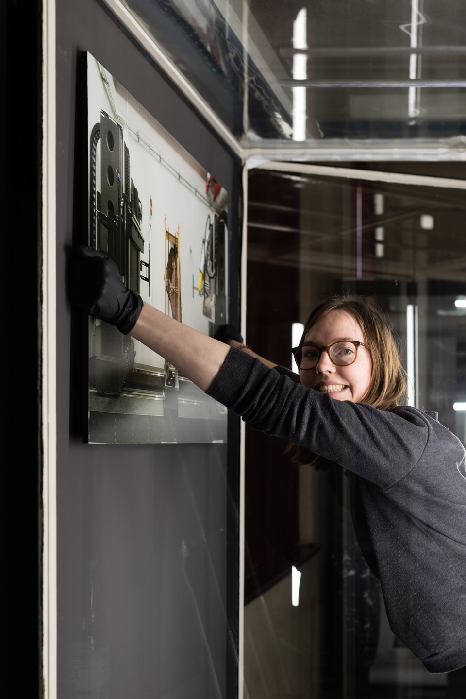 Lisa Janke bringt eine Fotografie in der Ausstellung an. Foto: HU Berlin.